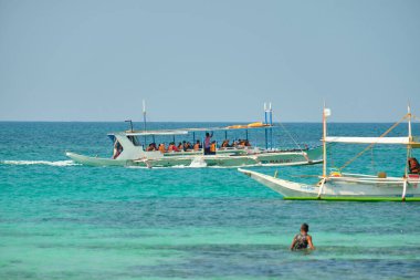 Boracay, Filipinler - 30 Ocak 2020: Gündüz vakti Boracay adasının boş beyaz plajı. Koronavirüs yüzünden Çinli turist yok. Denizdeki tekneler turist taşır.