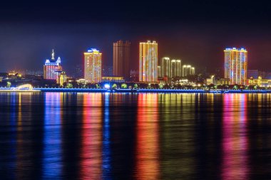 Blagoveshchensk, Rusya - Ekim 07, 2020: Blagoveshchensk şehrinin setinden Çin 'in Heihe şehrine bakınız. Gecenin ışıkları Amur nehrinin yansımasında..