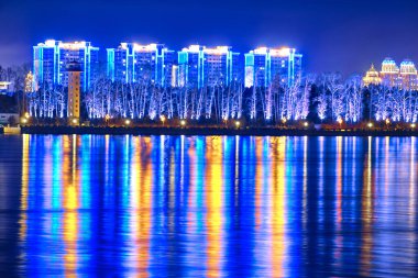 Blagoveshchensk, Rusya - Ekim 07, 2020: Blagoveshchensk şehrinin setinden Çin 'in Heihe şehrine bakınız. Gecenin ışıkları Amur nehrinin yansımasında..