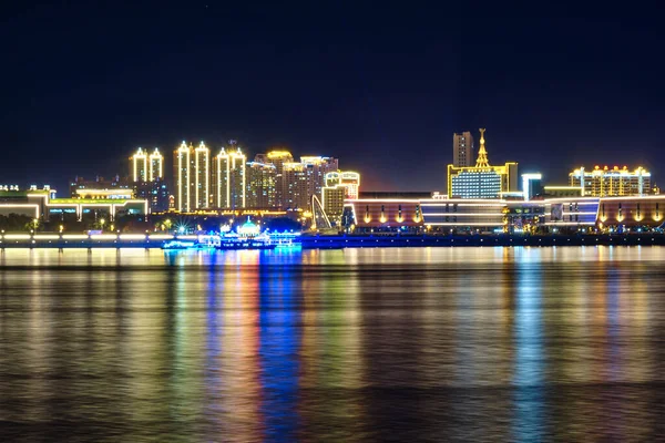 Blagoveshchensk, Rusland - 07 okt 2020: Zicht op de Chinese stad Heihe vanaf de dijk van de stad Blagoveshchensk. Licht van de nachtstad in de weerspiegeling van de rivier de Amur. — Stockfoto