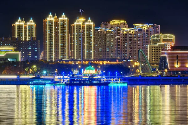 Blagoveshchensk, Rusland - 07 okt 2020: Zicht op de Chinese stad Heihe vanaf de dijk van de stad Blagoveshchensk. Licht van de nachtstad in de weerspiegeling van de rivier de Amur. — Stockfoto