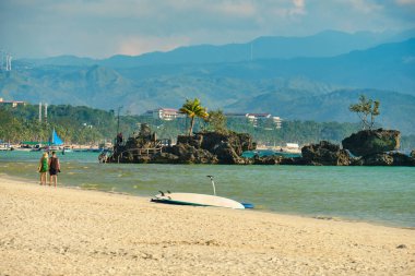 Boracay adasının beyaz plajı. Turistler plaj boyunca yürür ve denizde yüzerler. Coronavirüs salgınından birkaç gün önce.