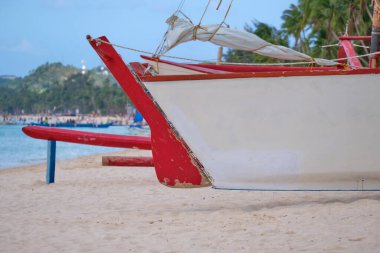 Boracay adasının beyaz plajı. Boracay adında bir yelkenli teknesi sahilde. Turistler plaj boyunca yürür ve denizde yüzerler. Coronavirüs salgınından birkaç gün önce.