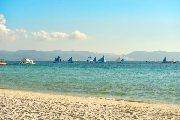 Boracay adasının beyaz plajı. Turistler plaj boyunca yürür ve denizde yüzerler. Coronavirüs salgınından birkaç gün önce.