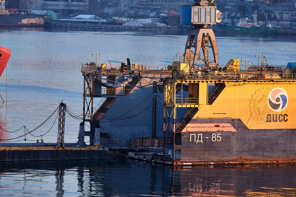 Vladivostok, Rusia - 26 de diciembre de 2020: Vista nocturna del puente en la bahía del enjambre de oro. La bahía del cuerno de oro en invierno. El barco está siendo reparado en el puerto. — Foto de Stock