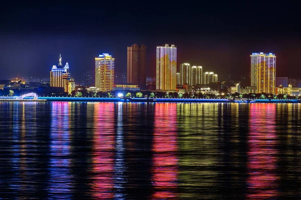 Blagoveshchensk, Rusia - 07 / 10 / 2020: vista de la ciudad china de Heihe desde el terraplén de la ciudad de Blagoveshchensk. Luces de la ciudad nocturna en el reflejo del río Amur. —  Fotos de Stock