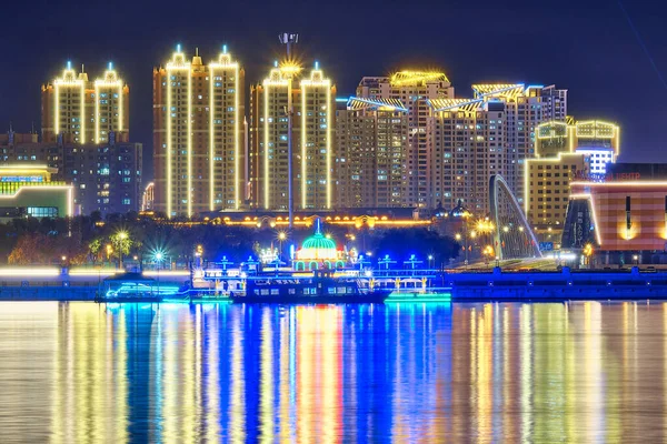 Blagoveshchensk, Rusland - 07 okt 2020: Zicht op de Chinese stad Heihe vanaf de dijk van de stad Blagoveshchensk. Licht van de nachtstad in de weerspiegeling van de rivier de Amur. — Stockfoto