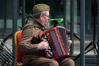 Khabarocsk, Rusya - 09 Mayıs 2019: Büyük Vatanseverlik Savaşı 'ndaki Zafer Günü onuruna verilen konser. Askeri üniformalı bir emekli akordeon çalıyor..