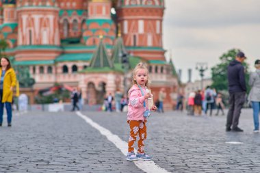 Moskova, Rusya - 27 Mayıs 2021: Çocuk kameralı küçük bir kız Kızıl Meydan boyunca yürüyor.
