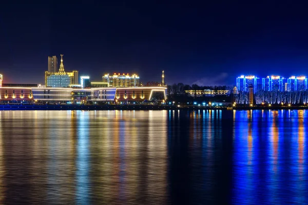 Blagoveshchensk, Rosja - październik 07, 2020: widok na chińskie miasto Heihe z nasypu miasta Blagoveshchensk. Światła nocnego miasta w odbiciu rzeki Amur. — Zdjęcie stockowe