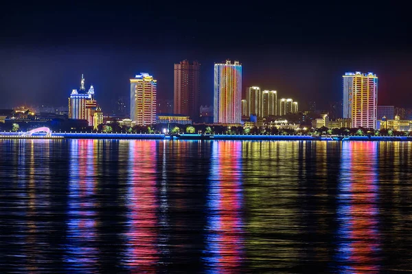 Blagoveshchensk, Rosja - październik 07, 2020: widok na chińskie miasto Heihe z nasypu miasta Blagoveshchensk. Światła nocnego miasta w odbiciu rzeki Amur. — Zdjęcie stockowe