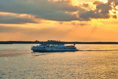 Khabarovsk, Rusya - 14 Temmuz 2020: Khabarovsk 'taki Amur nehrinin seti üzerinde gün batımı. Nehirde bir eğlence gemisi hareket ediyor. Amur nehrinin seviyesi yaklaşık 269 santimetre.