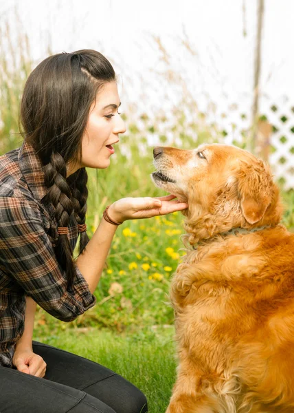 Bruneta žena chválí její pes pes zlatý retrívr — Stock fotografie