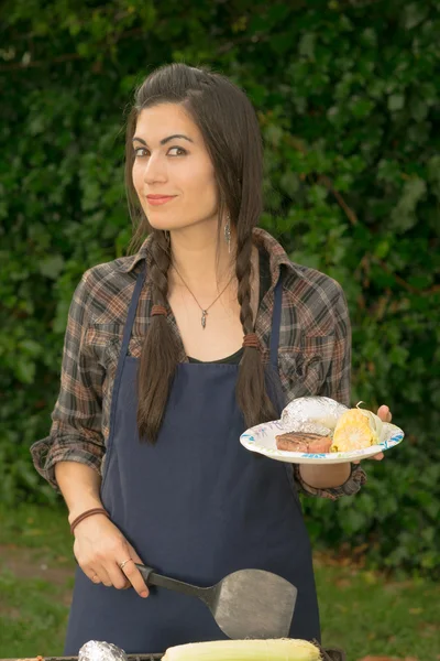 Biftek mangal arka bahçesinde yemek pişirme gülümseyen güzel kadın — Stok fotoğraf