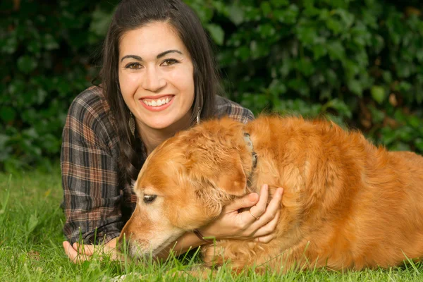 Bruneta žena chválit zlatý retrívr pes psí dvorku Gra — Stock fotografie