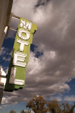 Neon Motel Sign Clear Blue Sky White Billowing Clouds clipart