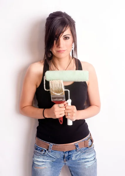 Hip jolie femme tenant des outils de peinture brosse rouleau — Photo