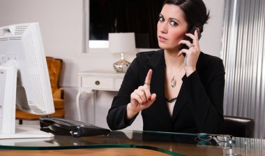 Office çalışan kadın cep telefonu üzerinde parmak sallayarak konuşuyor