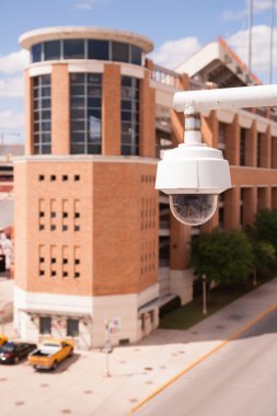 Video Security Camera Housings Mounted High on College Campus clipart