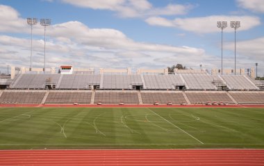 College Level Track Stadium Puffy Clouds Blue Sky clipart