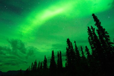 Aurora Borealis bulutlar uzak Alaska ile ortaya çıkar.