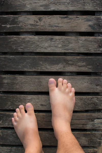Male bare feet on a wooden floor
