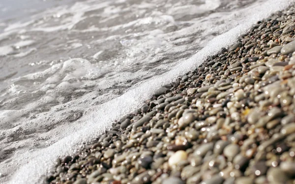 Havet surfa på pebble beach — Stockfoto