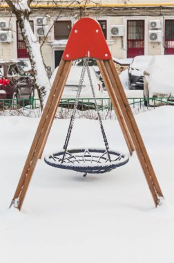 Gerçek boş çocuk turu kış günü bahçede sallanıyor.