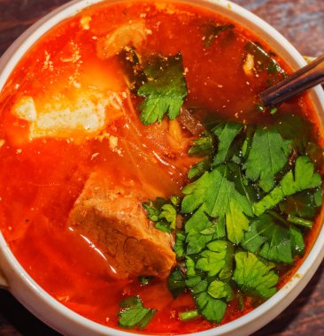 Beyaz kasede sığır eti ve otlarla çok lezzetli bir pancar çorbası.