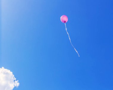 Mavi gökyüzünde gerçekten eğlenceli pembe bir balon güneşli bir arka plan