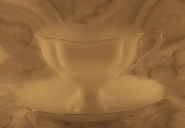 White porcelain cup with saucer in sepia — Stock Photo, Image