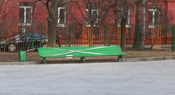 Zelené lavičky v parku s zakazující páska — Stock fotografie