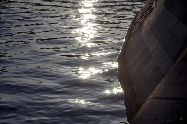 Zonnestralen op het water langs de promenade — Stockfoto
