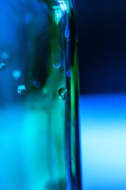 Mavi-yeşil cam şişe su damlaları