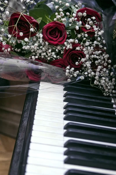 Bukiet ciemno czerwonych róż na fortepian — Zdjęcie stockowe