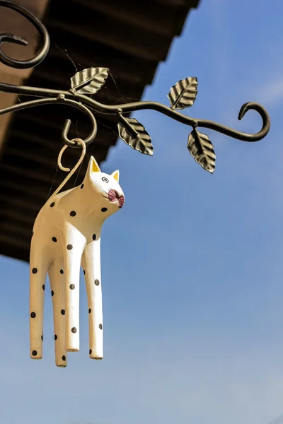Деревянная фигурка висящей кошки — стоковое фото