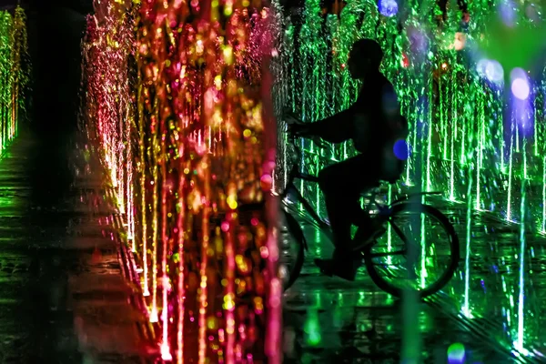 Homem na fonte da noite na bicicleta — Fotografia de Stock