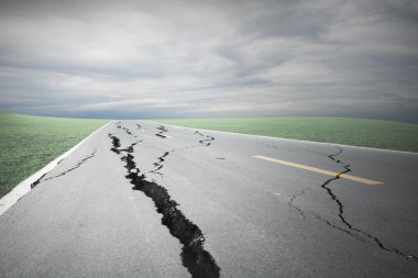 Asfalt yol çatlaklar ve fırtına bulutu ile çöktü