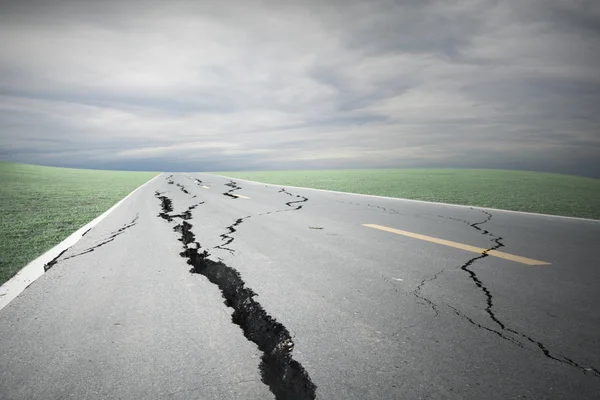 Asphalt road cracks and collapsed with storm cloud — Stock Photo, Image