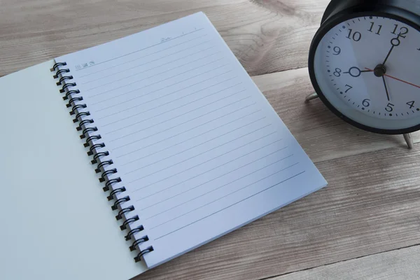 Caderno e relógio com piso de madeira — Fotografia de Stock