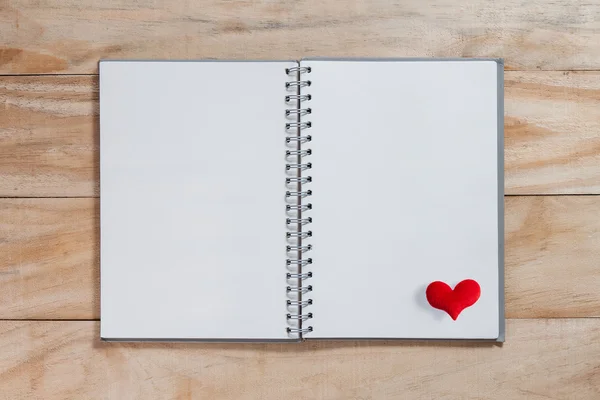 Cuaderno con corazón rojo en la mesa de madera, fondo de San Valentín — Foto de Stock