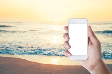 el smartphone plaj arka plan ile tutarak.