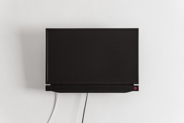 Black LCD or LED tv screen hanging on a wall clipart