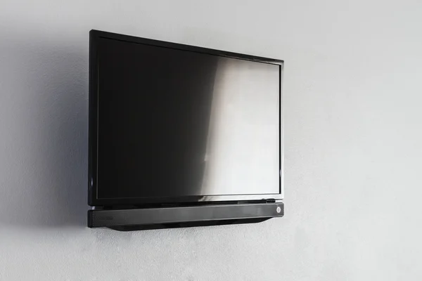 หน้าจอ LCD สีดําหรือ LED TV แขวนอยู่บนผนัง — ภาพถ่ายสต็อก
