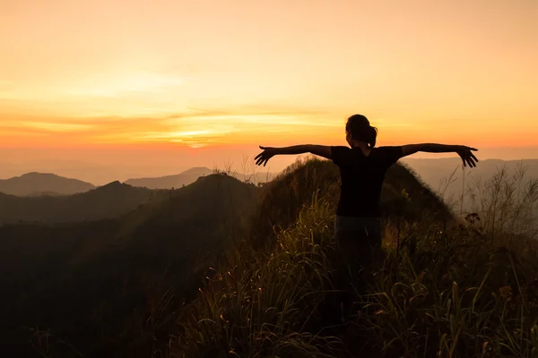 Femme bénéficiant d'une vue coucher de soleil depuis le sommet d'une montagne — Photo