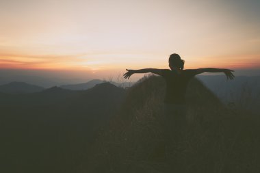 Bir dağın tepesinde kaldırdı elleriyle genç mutlu kadın