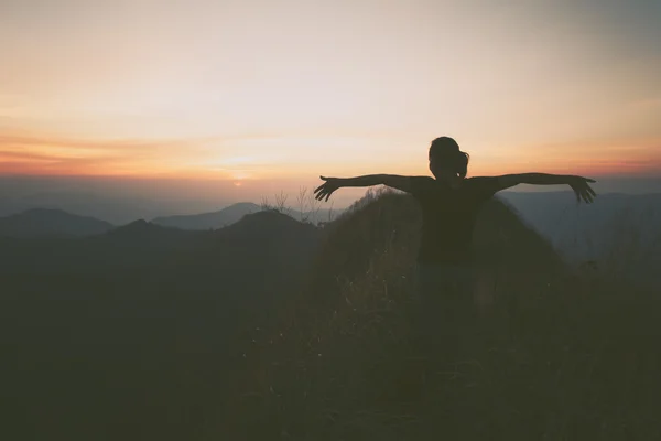 Bir dağın tepesinde kaldırdı elleriyle genç mutlu kadın