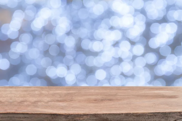 Beyaz parlak bokeh ışıklar önünde ahşap masa