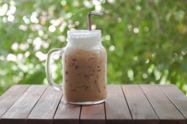 Buzlu kahve doğa arka plan ile ahşap bir masa üzerinde