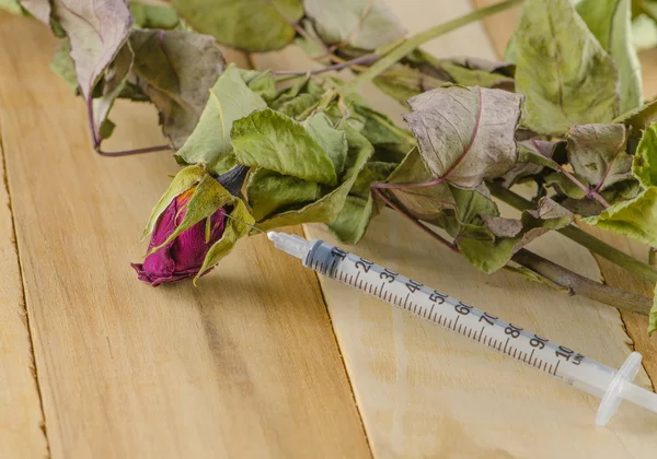 Dried rose and syringe — Stock Photo, Image